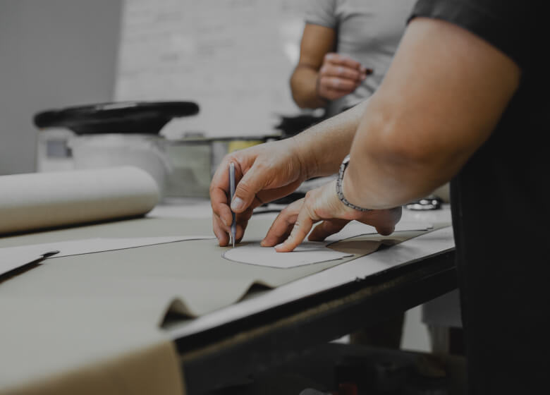 A designer cutting leather for a piece of furniture